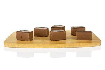 Group of six whole sweet brown viennese nougat on bamboo cutting board isolated on white background