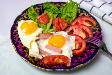 Fried eggs with tomatoes and lettuce
