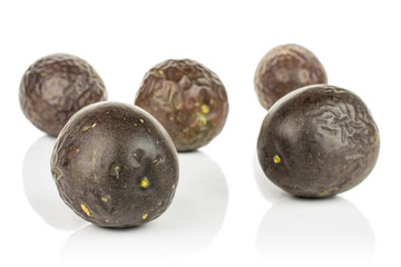 Group of five whole sweet dark purple passion fruit isolated on white background