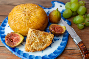 cheese, figs, grapes and knife on cutting board