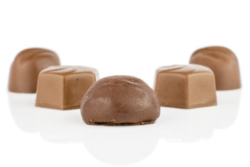 Group of five whole delicious chocolate praline placed symmetrically isolated on white background