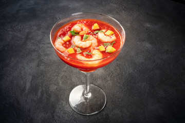 Coctel de gambas, Mexican shrimp cocktail with avocado, on a dark background with a place for text