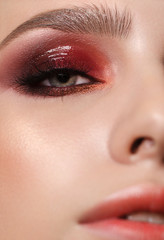 Attractive young beauty model with professional make up, perfect skin and nude lips. Trendy glossy colorful smoky eyes