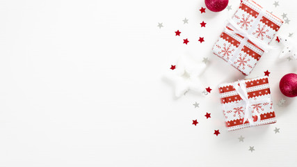 Fototapeta na wymiar Top view vintage Christmas presents over white background with festive decorations, star, balls, confetti. Flat lay, copy space. Christmas greeting card mockup, New Year banner template.