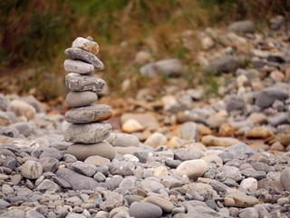 Tall balance stone tower against organic nature background. Concept patience at reaching your...