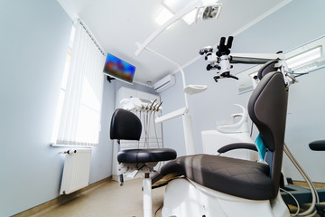 Modern dentistry office interior with chair and tools. Microscope in stomatology.