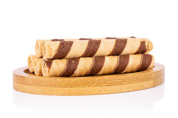 Group of five whole crunchy beige hazelnut rolled wafer biscuit on bamboo coaster isolated on white background