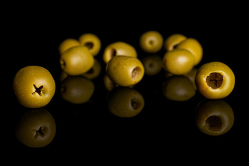 Lot of whole pitted green olive isolated on black glass