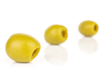Group of three whole pitted green olive isolated on white background