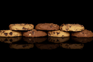 Group of seven whole sweet brown cookie isolated on black glass
