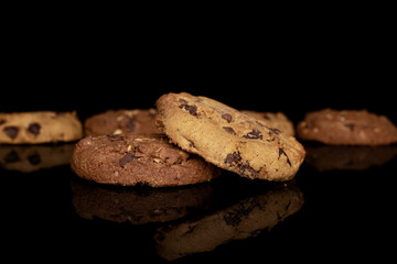 Group of six whole sweet brown cookie isolated on black glass