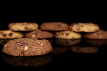 Group of eight whole sweet brown cookie one in focus isolated on black glass