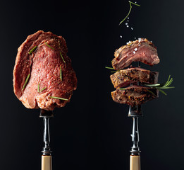 Grilled and uncooked beef steak with rosemary on a black background.