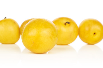 Group of five whole fresh yellow plum isolated on white background