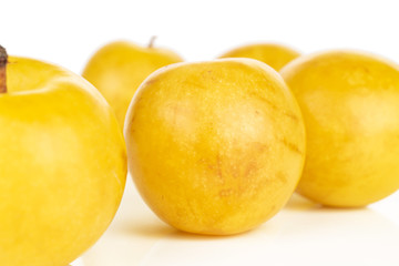 Group of five whole fresh yellow plum isolated on white background