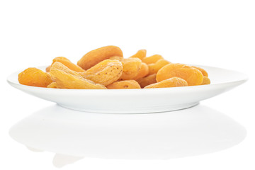 Lot of whole dried orange apricot on white ceramic plate isolated on white background