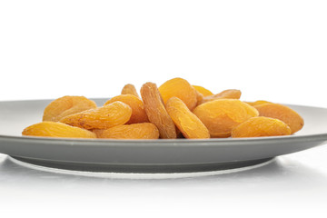 Lot of whole dried orange apricot heap in glazed bowl isolated on white background