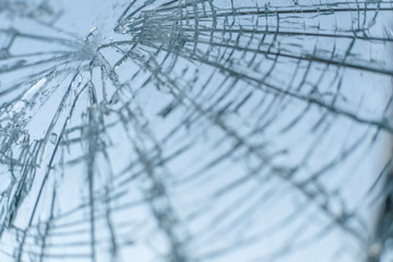 broken windshield of the car against the blue sky. background, texture