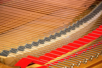 Closeup of a piano inside, parallel strings in a diagonal composition.