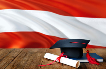 Austria education concept. Graduation cap and diploma on wooden table, national flag background....