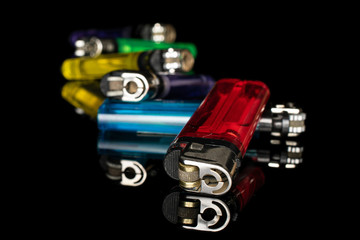 Group of six whole plastic lighter isolated on black glass