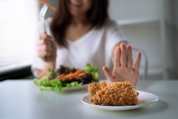 Dieting and good health concept, the young lady refused fried food and chose healthy food.