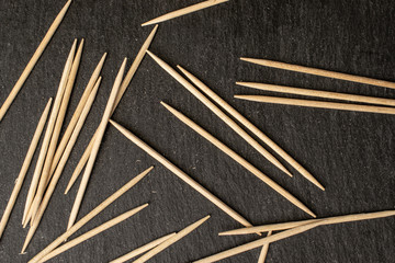 Lot of whole disordered wooden brown toothpick flatlay on grey stone