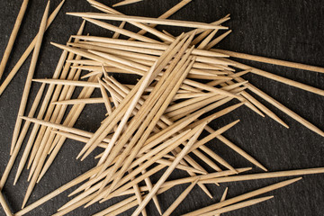 Lot of whole disordered wooden brown toothpick flatlay on grey stone