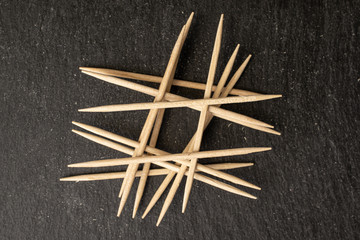 Lot of whole arranged wooden brown toothpick flatlay on grey stone