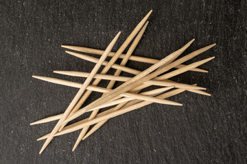 Lot of whole arranged wooden brown toothpick flatlay on grey stone