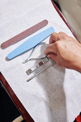 Manurist taking disinfected professional manicure tools laying on paper napkin