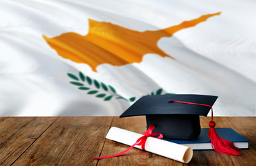Cyprus education concept. Graduation cap and diploma on wooden table, national flag background....
