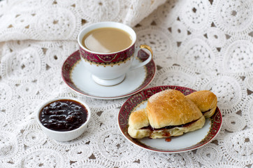 Cup of coffee and croissant with jam