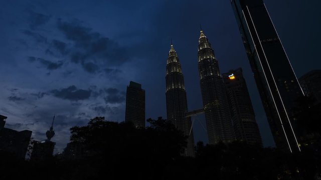 Day to night time lapse video of the Petronas Twin Towers seen from the KLCC Park. The Petronas Towers are twin skyscrapers in Kuala Lumpur, Malaysia.