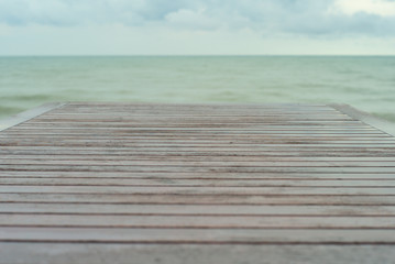 Fototapeta premium Selective focus on wooden table surface with blurred horizontal line and blue cloudy sky in background