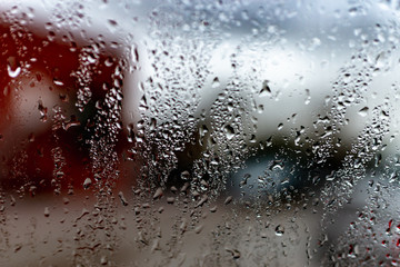 Rain drops on a window against cloudy sky. city in rainy season