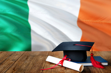 Ireland education concept. Graduation cap and diploma on wooden table, national flag background....