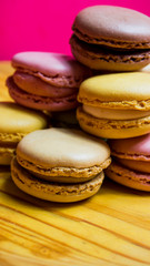 Colored macarons isolated on wooden dish, typical French dish