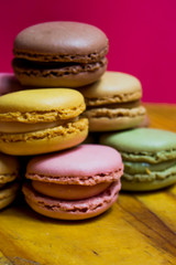 Colored macarons isolated on wooden dish, typical French dish