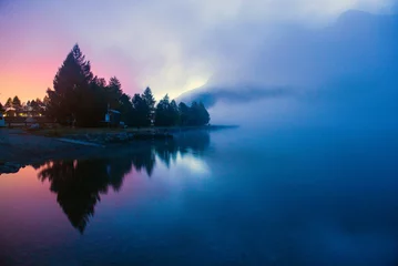 Fototapete Berge Nebel über einem Bergsee vor der Morgendämmerung.