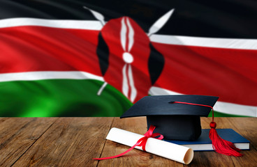 Kenya education concept. Graduation cap and diploma on wooden table, national flag background....