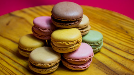 Colored macarons isolated on wooden dish, typical French dish