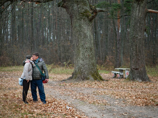 Fototapeta premium man and woman in a forest with red leaves in autumn outdoors