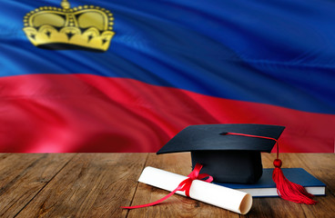 Liechtenstein education concept. Graduation cap and diploma on wooden table, national flag background. Succesful student.