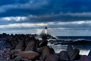 Fototapeta na wymiar Brekwater and lighthouse in storm, Ventspils, Latvia.