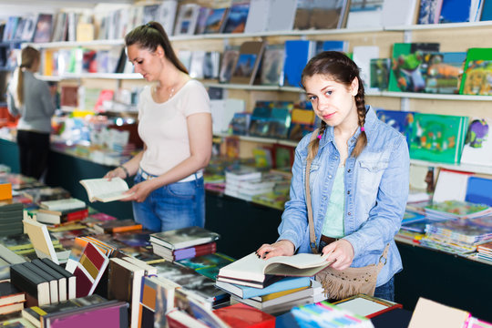 Smiling girl is flipping books
