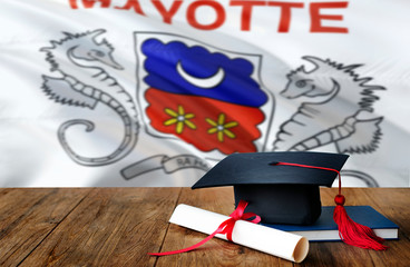 Mayotte education concept. Graduation cap and diploma on wooden table, national flag background. Succesful student.