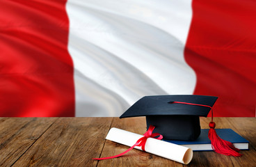 Peru education concept. Graduation cap and diploma on wooden table, national flag background....