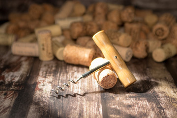 Fototapeta na wymiar corkscrew and corks on wooden background