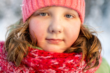 Portrait of beautiful little girl looking at camera outdoor in winter day.